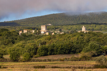 Obraz premium Monteriggioni emerging from the Tuscan countryside with cloudy sky