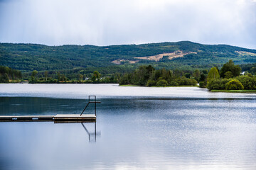 Peaceful Lakeside View with Dock and Forested Hills