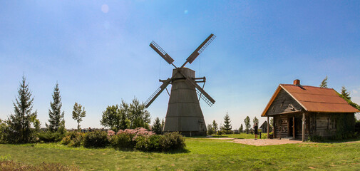 Classic Dutch-type wooden windmill with four blades and traditional guest house at Dudutki open-air...