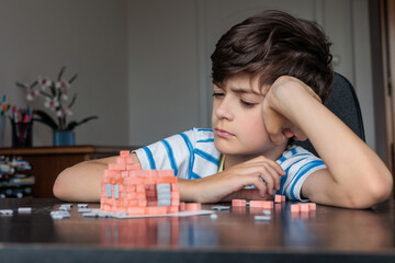 Frustrated child struggling with building blocks at home. learning difficulties. concentration...