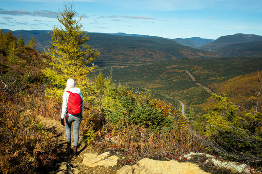 Hiker explores a scenic mountain trail during autumn in a vibrant landscape in daylight