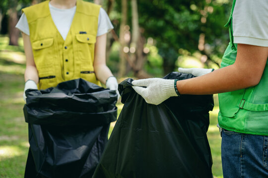 Dedicated volunteers meticulously organize outdoor park cleanup collecting diverse waste for recycling fostering environmental sustainability community well being