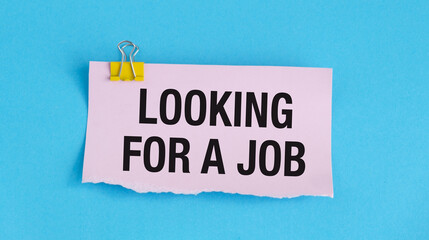 A pink piece of paper with a yellow clip holding it. The paper says looking For a Job
