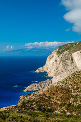 Zakynthos Greece dramatic white sea cliffs with green hills and deep blue water under clear summer sky popular coastal view and travel photo spot