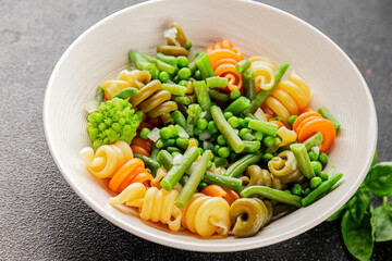 Trottole pasta vegetables green peas, green beans, kohlrabi cabbage, broccoli second course tasty snack fresh delicious gourmet food background on the table rustic food top view copy space