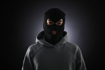 Criminal man in mask on dark background