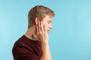 Sound. Man with hearing problem on light blue background, space for text