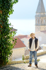 A cute teenage tourist is traveling through the old town of Perast, Montenegro.