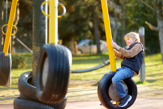Cute preteen boy having fun on outdoor playground. Spring summer autumn active sport leisure for child. Activity for family with children. Equipment of entertainment park for kids. - Powered by Adobe