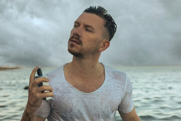Young guy and a bottle of perfume