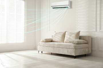 Sofa with pillows in living room. Air conditioner keeping comfortable temperature indoors