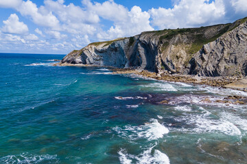 Atlantic coast and ocean. Rocks on the coastline. View from above. Blue sky with clouds. Seascape