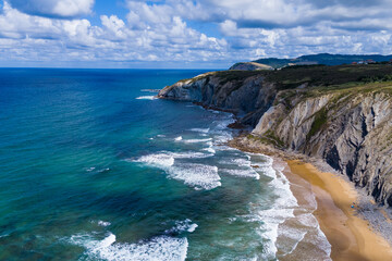 Atlantic coast and ocean. Rocks on the coastline. View from above. Blue sky with clouds. Seascape