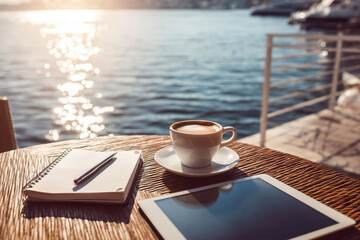 Coffee and Tablet by the Waterfront on a Bright Sunny Morning