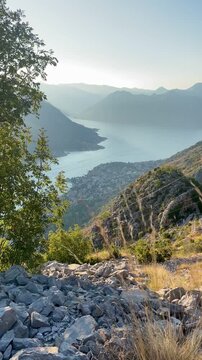 Boka Kotor Bay AerScenic aerial view of Boka Kotor Bay with emerald water, green mountains, and coastal towns shining in bright Mediterranean daylight.ial Panorama. High quality FullHD footage