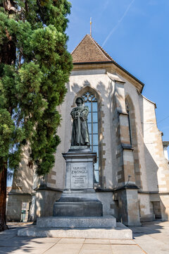 Statue of reformer Huldrych Zwingli by Austrian sculptor Heinrich Natter in front of the late Gothic Wasserkirche on the Limmat river, Zurich, Switzerland