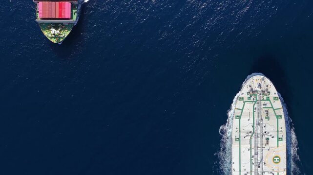 Aerial overhead view of a cargo container ship and a crude oil tanker crossing the ocean as a concept for industrial transport