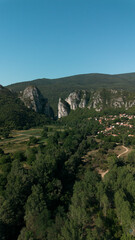 Obraz premium Aerial view of Jerma Canyon in Serbia with a small village surrounded by rocky cliffs and green forest