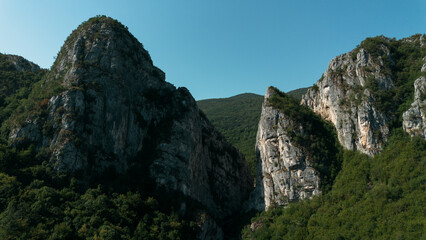 Close aerial view of dramatic rocky cliffs in Jerma Canyon mountains, Serbia country, surrounded by dense forest