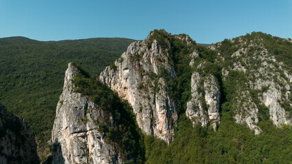 Close aerial view of dramatic rocky cliffs in Jerma Canyon mountains, Serbia country, surrounded by dense forest