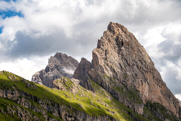 Dramatic mountain peak of Gran Fermeda and Sass Rigais rising sharply against a partly cloudy sky in Val Gardena in the Italian Dolomites alps 