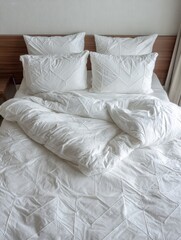 Cozy White Bedding Neatly Arranged on a Wooden Bed Frame in a Bright and Inviting Bedroom