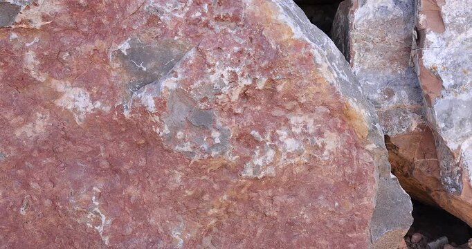 Closeup motion on rough surface Muti tan color rock with gray color erosion on dry stack wall 4k