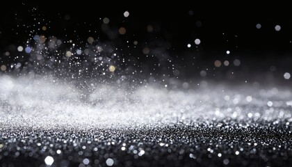 The image shows silver glitter particles of varying sizes and brightness scattered on a black background, creating a sparkling effect.