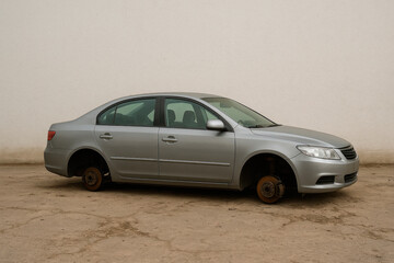 Obraz premium A gray car without wheels against the background of a wall.
