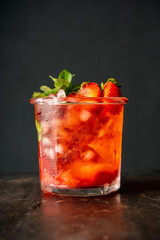Fresh summer cocktail with strawberry and ice. Strawberry soda drink on the rustic background.