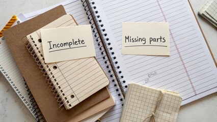 Notes on Desk with Labels Indicating Incomplete and Missing Parts