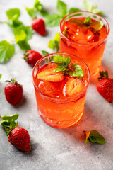 Fresh summer cocktail with strawberry and ice. Strawberry soda drink on the rustic background.