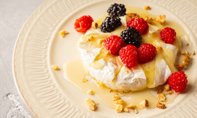 Grilled brie cheese with berries and honey. Dessert with natural ingredients.