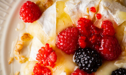 Grilled brie cheese with berries and honey. Dessert with natural ingredients.