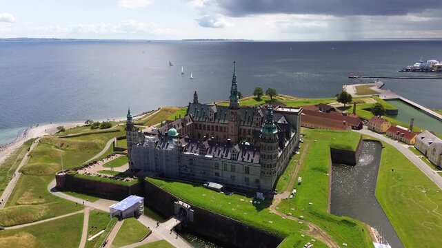 Aerial video of Konborg Castle in Denmark on a sunny day with the sea behind it.