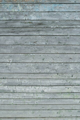 Obraz premium A weathered gray wooden wall with horizontal planks and peeling paint