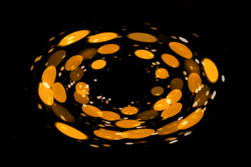 Abstract image of glowing golden circles with dark background