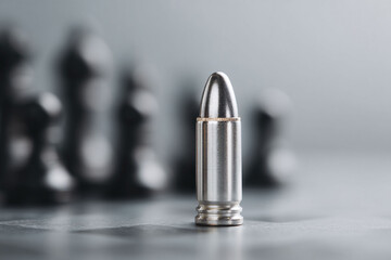 A single bullet stands in sharp focus, backed by blurred figures. Symbolizes power, threat, and precision. Evokes themes of security, defense, and conflict.