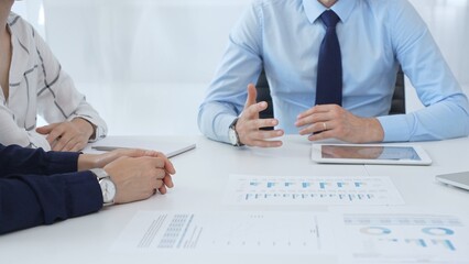 Business people reviewing financial metrics on digital screens, collaborating strategically while examining charts and graphs in office