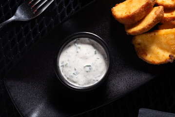 Mayonnaise Sauce with Herbs in Small Bowl on Black Tray, Top View
