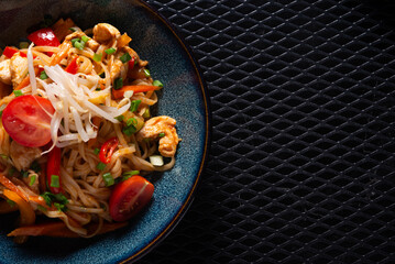 Noodles with Chicken and Vegetables on Dark Plate with Copy Space, Top View
