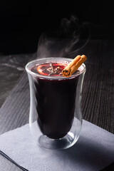 Hot Mulled Wine with Orange Slice and Cinnamon Stick in Glass on Dark Table with Steam