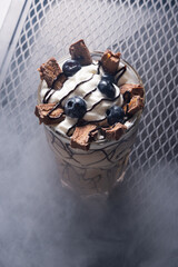 Chocolate Milkshake with Whipped Cream and Chocolate in Glass on Dark Table, Top View