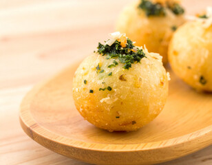 Takoyaki Balls with Green Topping on Wooden Plate Close-Up
