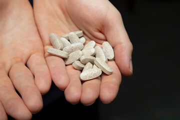 Vitamin pills in human hands.