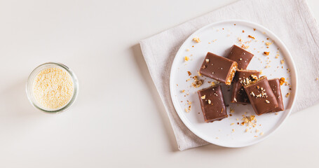 Chocolate nut protein bars on a plate on a table top view web banner