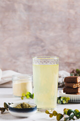 Matcha protein drink in a glass, powder and protein bars on table vertical view