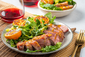 A plate of meat and salad with a fork and knife on the table