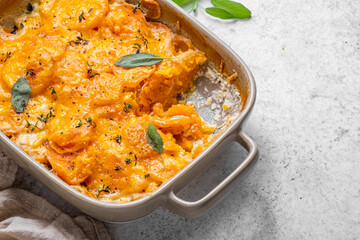 A casserole dish with a yellowish orange color and a white lid
