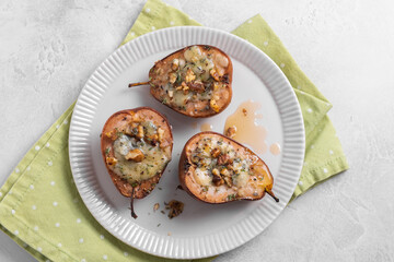 Three pears with cheese on top of a white plate